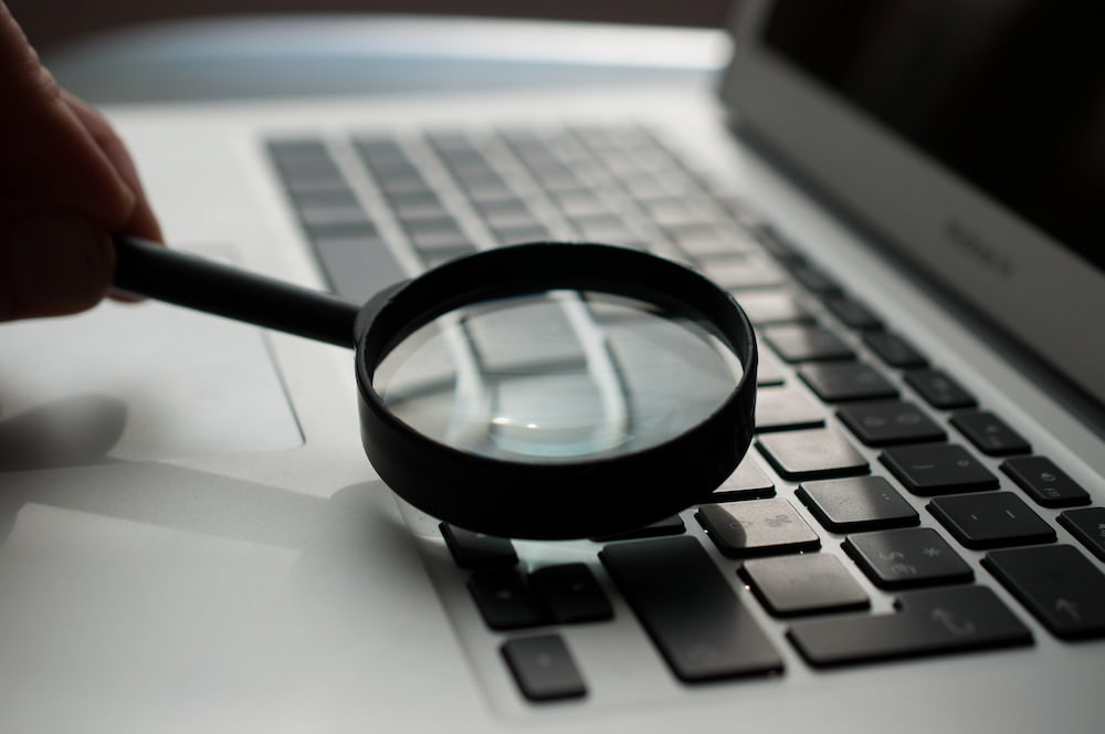 Magnifying glass and laptop Magnifying glass and laptop